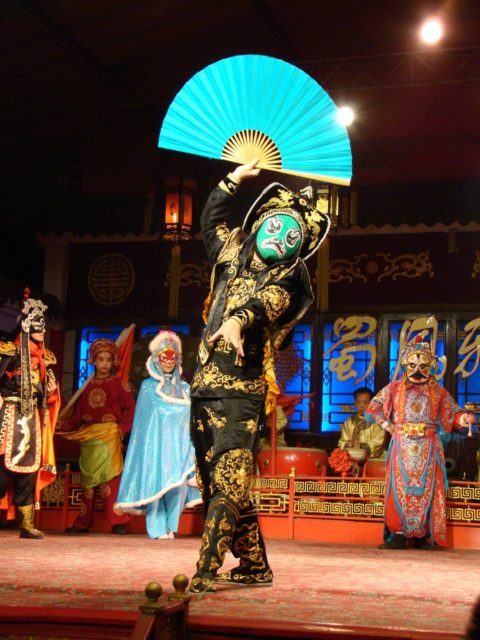 Energetisches Feng Sui, Jahreskreisfest Lughnasadh, chinesische Oper, Schauspieler mit Masken und bunten Kostümen, türkiser Fächer, rot, türkis, blau, schwarz, gold