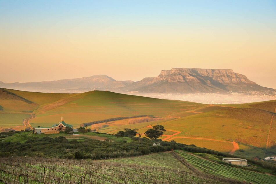 Nature 4430922 1280 Energetisches Feng Shui, Elementarkraft Erde, hügelige Landschaft mit Feldern und Farm mit Tafelbergen im Hintergrund, ocker, grün, altrosa