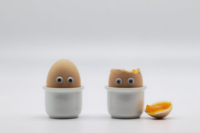 Ostereier 26 Triputi-Emotionscode in Berlin, Osterspezial, Easter egg, braune Eier mit Augen in weißen Eierbechern, eins ist aufgeschlagen